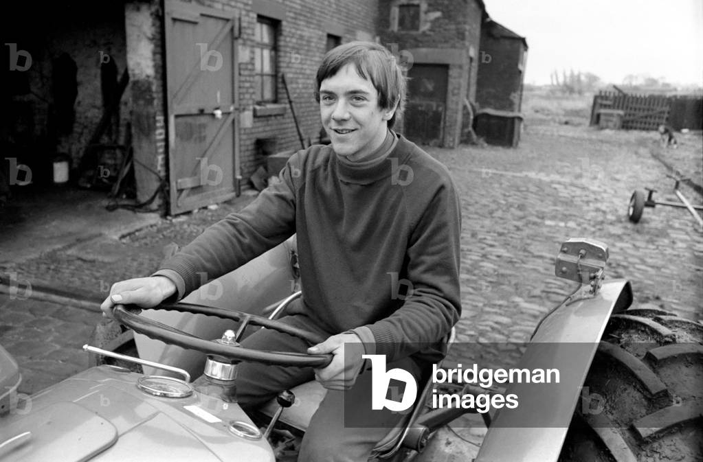 Sport. Football: Sixteen yr old Ronald Aspinwall. He manages Carr Farm. Lathom, near Ormskirk and has been approached by a Chelsea FC coach. Training during his lunch break in the farmyard Ronald Aspinwall practises ball control. Pictured here on his tractor in the yard. December 1969 (photo)