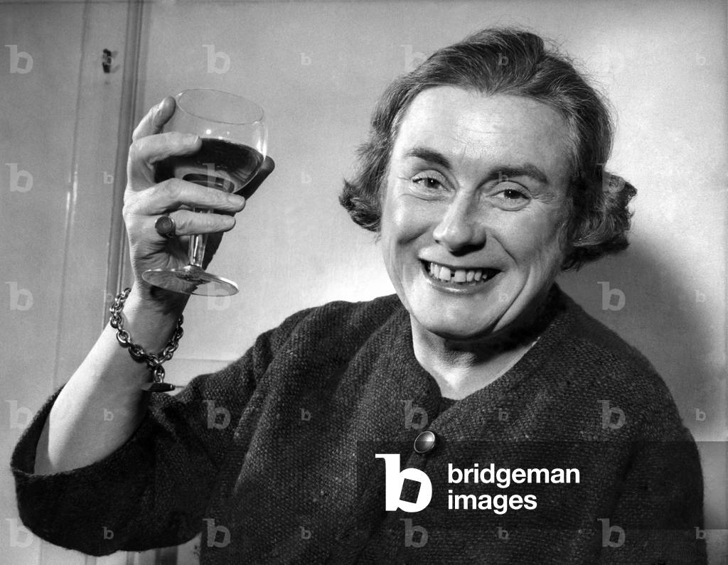 Miss. Gwen Robyns raises a glass of wine. 
December 1960