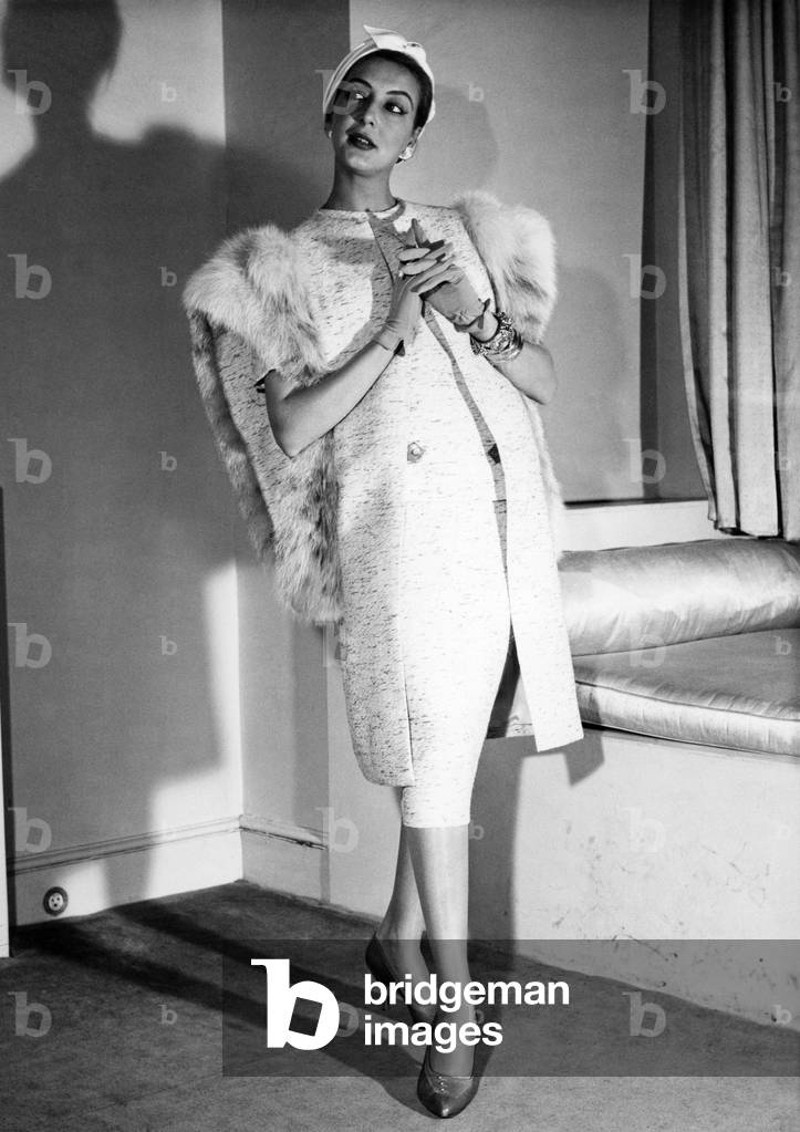 Fashions: Hartnell's number one. This luxury travel outfit from royal dressmaker Hartnell was among a collection of Spring Fashions from the top London designers. Snow lepard trims the tunic coat, which top the hip-length overblouse and straight skirt. February 1958