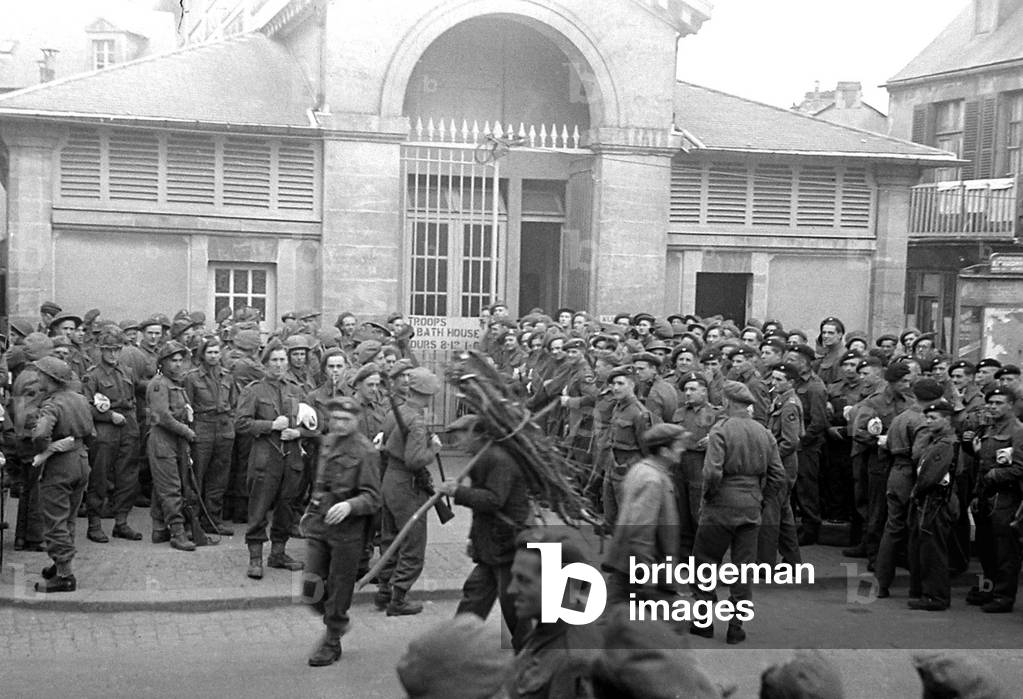 British troops outside the bath house in a Normandy town in Northern France shortly after the D-Day landings begun the Allied invasion of the continent during World War Two, 05/07/1944 (b/w photo)