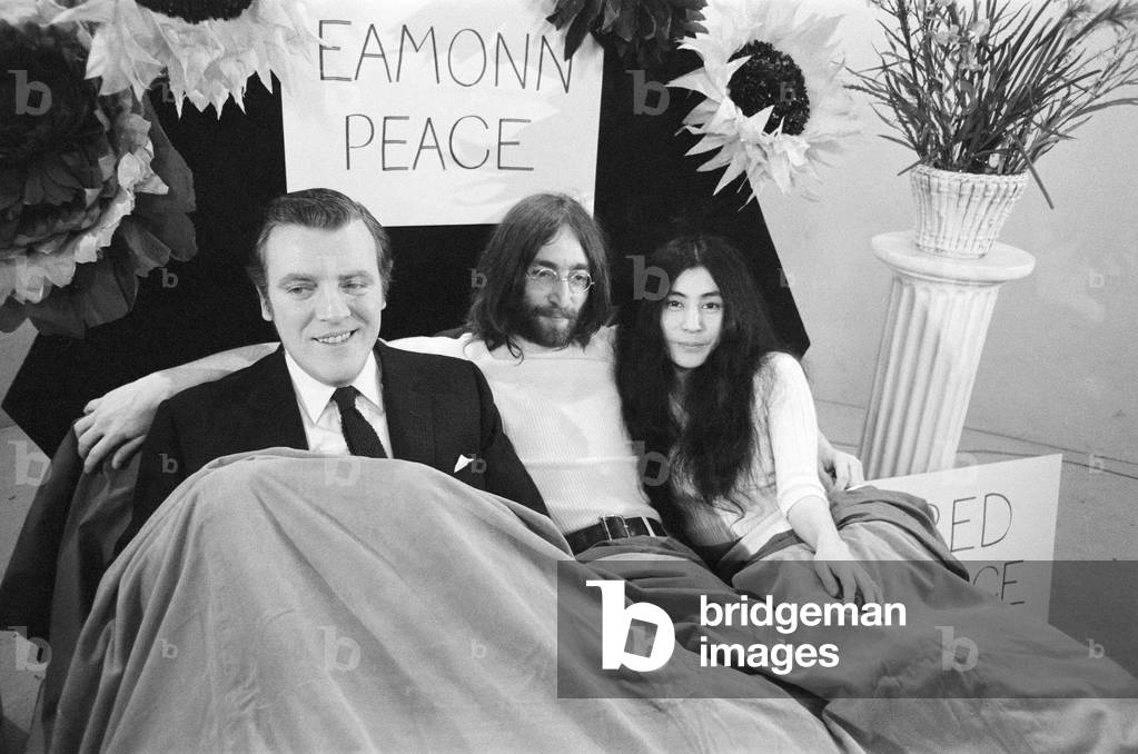 John Lennon and Yoko Ono appear on Thames Television's 'Today' programme with Eamonn Andrews. Eamonn started the programme in a bed and was joined by John and Yoko who emerged out of a bag at the bottom of the bed. 1st April 1969 (b/w photo)