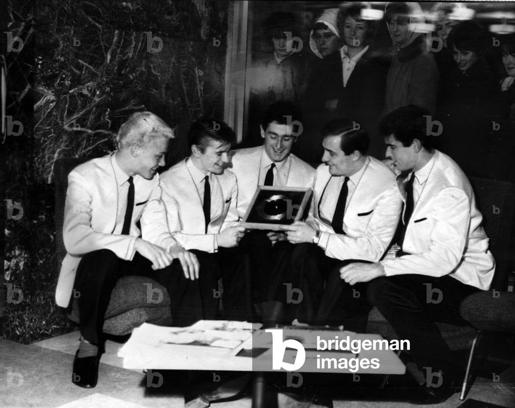 The Tornados pop group l-r Heinz Burt, George Bellamy, Roger Lavern, Alan Caddy and Clem Cattini with fans looking in through the window of the foyer at the Alpha Television Studios, Aston, Birmingham. 10th December 1962 (b/w photo)
