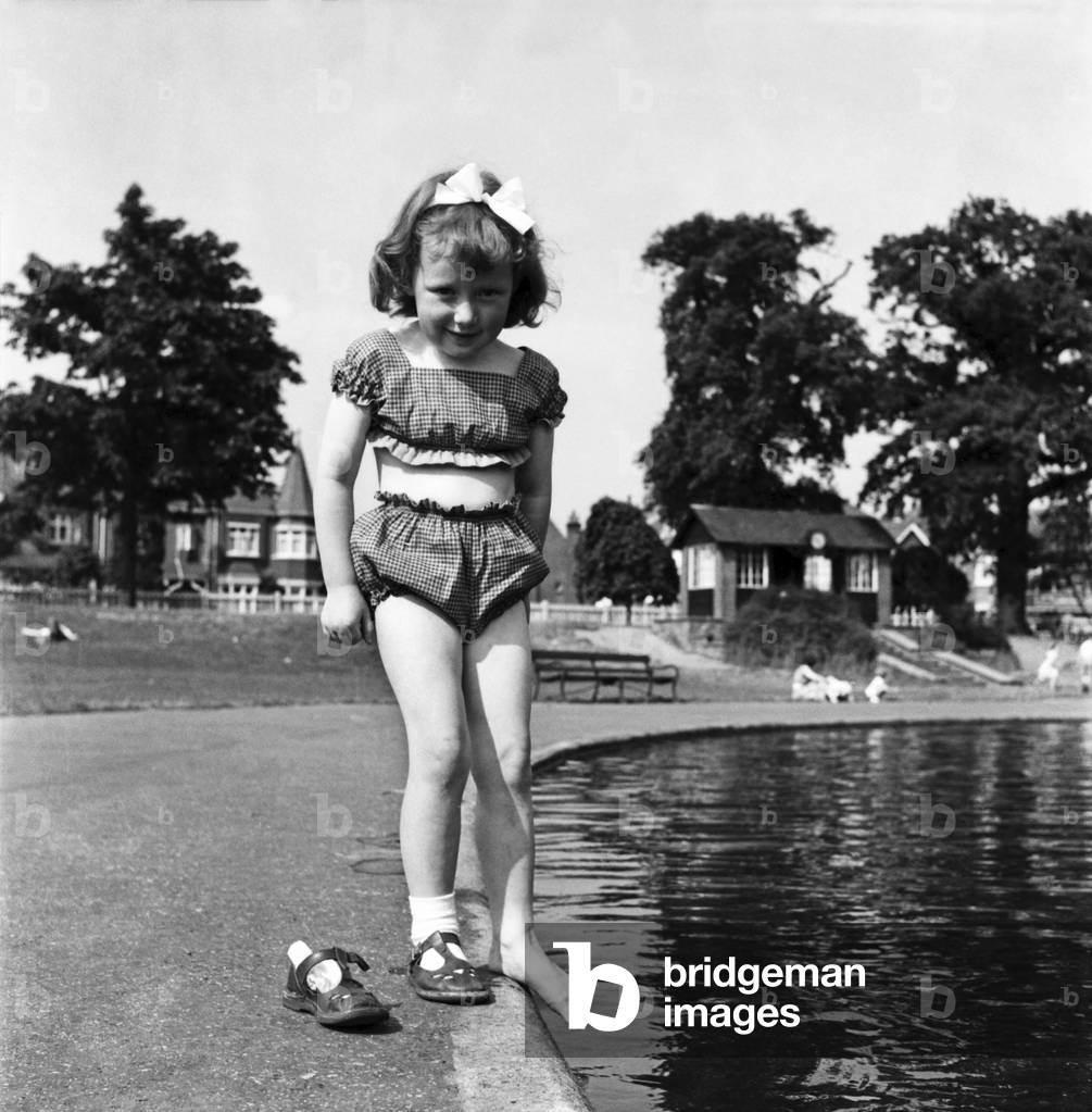 Holidays, little girl modelling swimsuit, June 1953 (b/w photo)