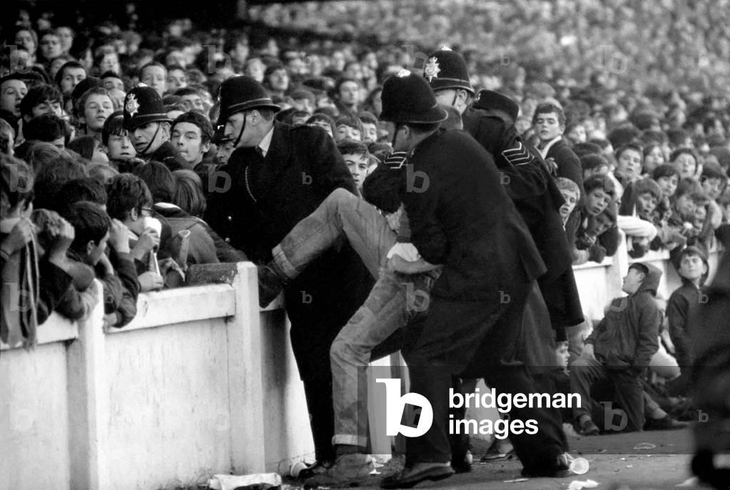 English League Division One match at Highfield RoadCoventry City 1 v Manchester United 2. Troublemaker is escorted out of the ground by policeNovember 1969 (photo)
