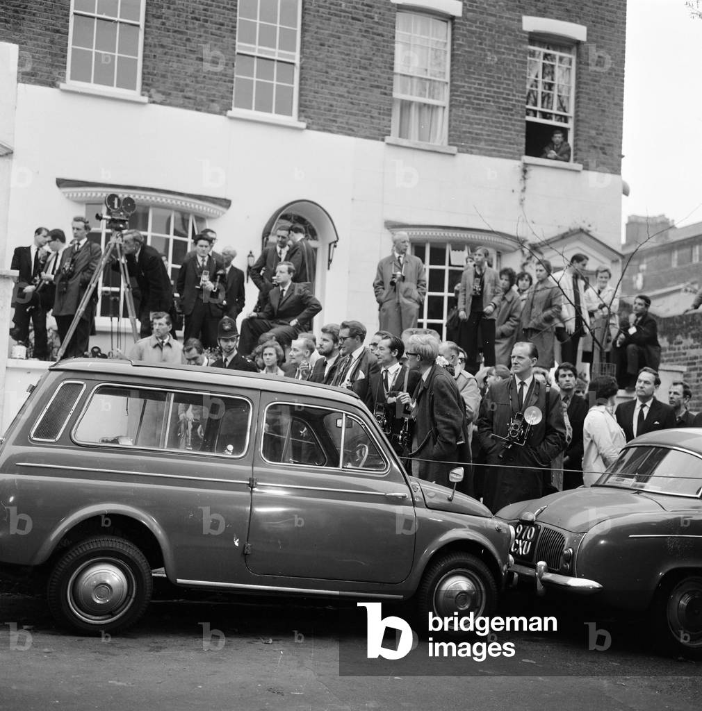 Photographers & journalists wait by Bardot's car, in London, 1963 (b/w photo)