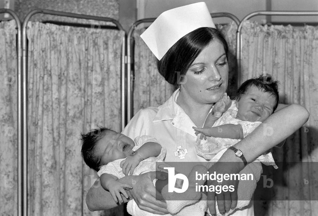 New Year babies at St. Teresa's Wimbledon. The new baby girls born within two hours of each other. Lucinda Rink 61bs 14 ozs and Nicole Leila Margossian 81bs 12ozs. They are held by Nursery Nurse Mary Harris. (Left Nicole Leila and right Lucinda), January 1975