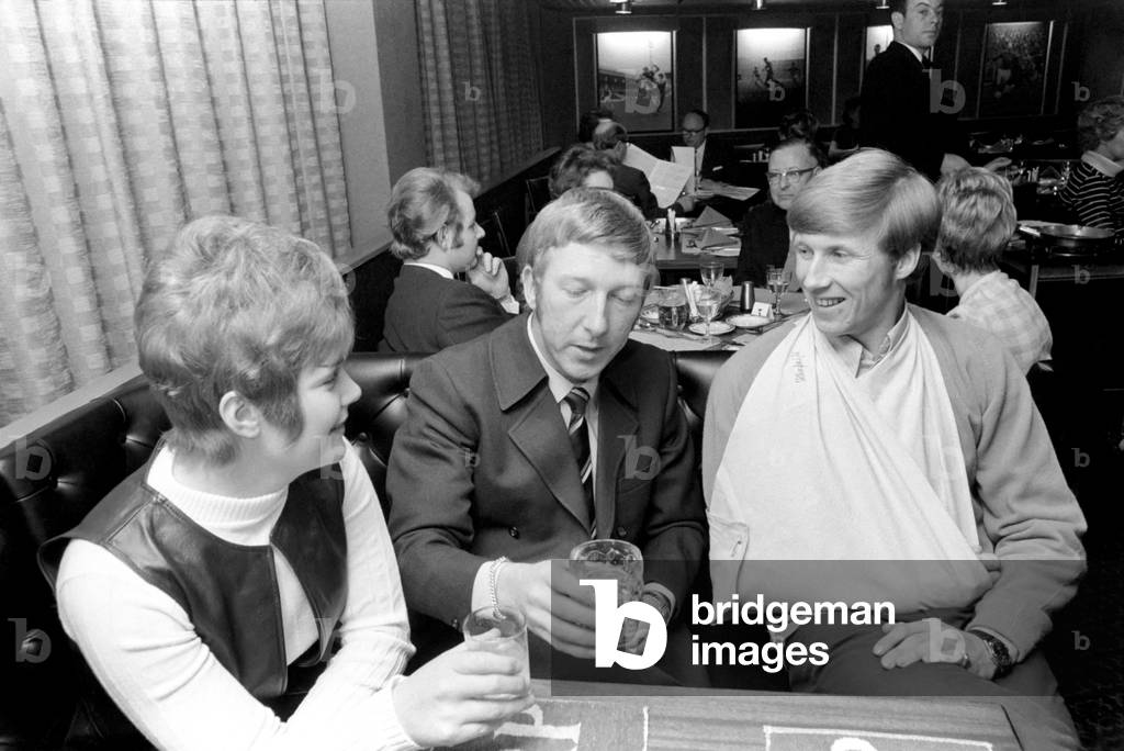 Manchester City and England star Colin Bell nursing his damaged shoulder, injured in Wednesday night's International match, at his Whitefield, Lancashire restaurant with a friend. December 1969 (photo)