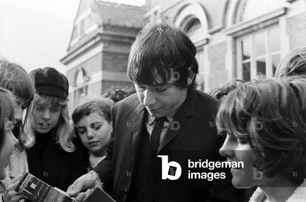 Eric Burdon, lead singer of British rock group The Animals at Uxbridge Court where he was fined £200. Here he is pictured signing autographs for fans as he leaves court. 1st November 1965 (b/w photo)