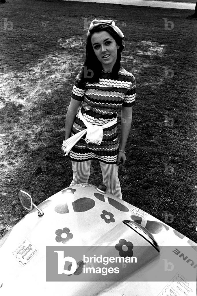 A model in a beach buggy wearing a dress, April 1970 (b/w photo)
