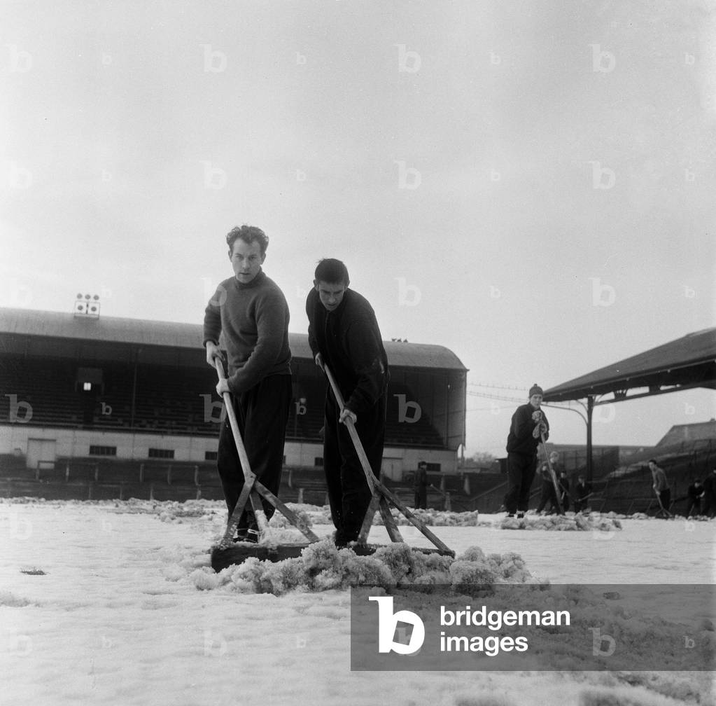 Manager Joe Harvey and players, clear snow from pitch at St James Park, home of Newcastle United Football Club. 1st February 1963 (photo)