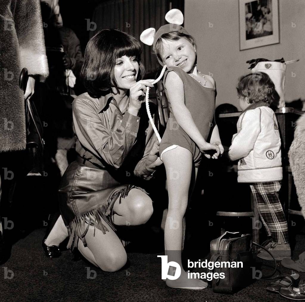 Joan Collins acting as dresser to her 5 year old daughter Tara who was playing the part of a mouse in Snow White at the Scala Theatre, November 1968 (b/w photo)