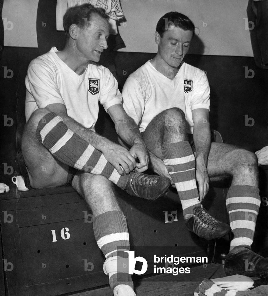 D. H. Hutchinson, Tom Finney's Testimonial match. Tom pictured taking boots off for last time with Jimmy Mcllroy. September 1960 (photo)