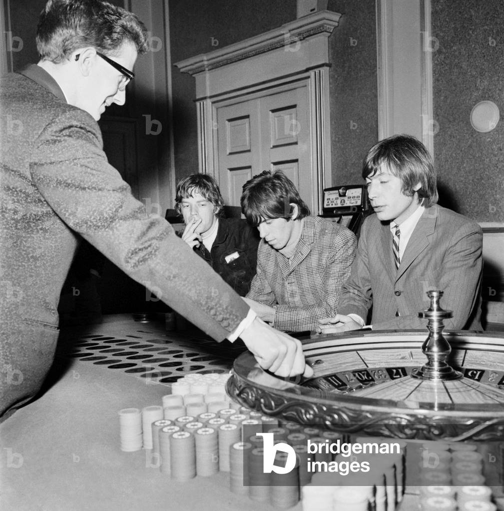 The Rolling Stones: Three of the Rolling Stones Mick Jagger, Keith Richard, and Charlie Watts play roulette at Douglas in the Isle of Man.
September 1965.