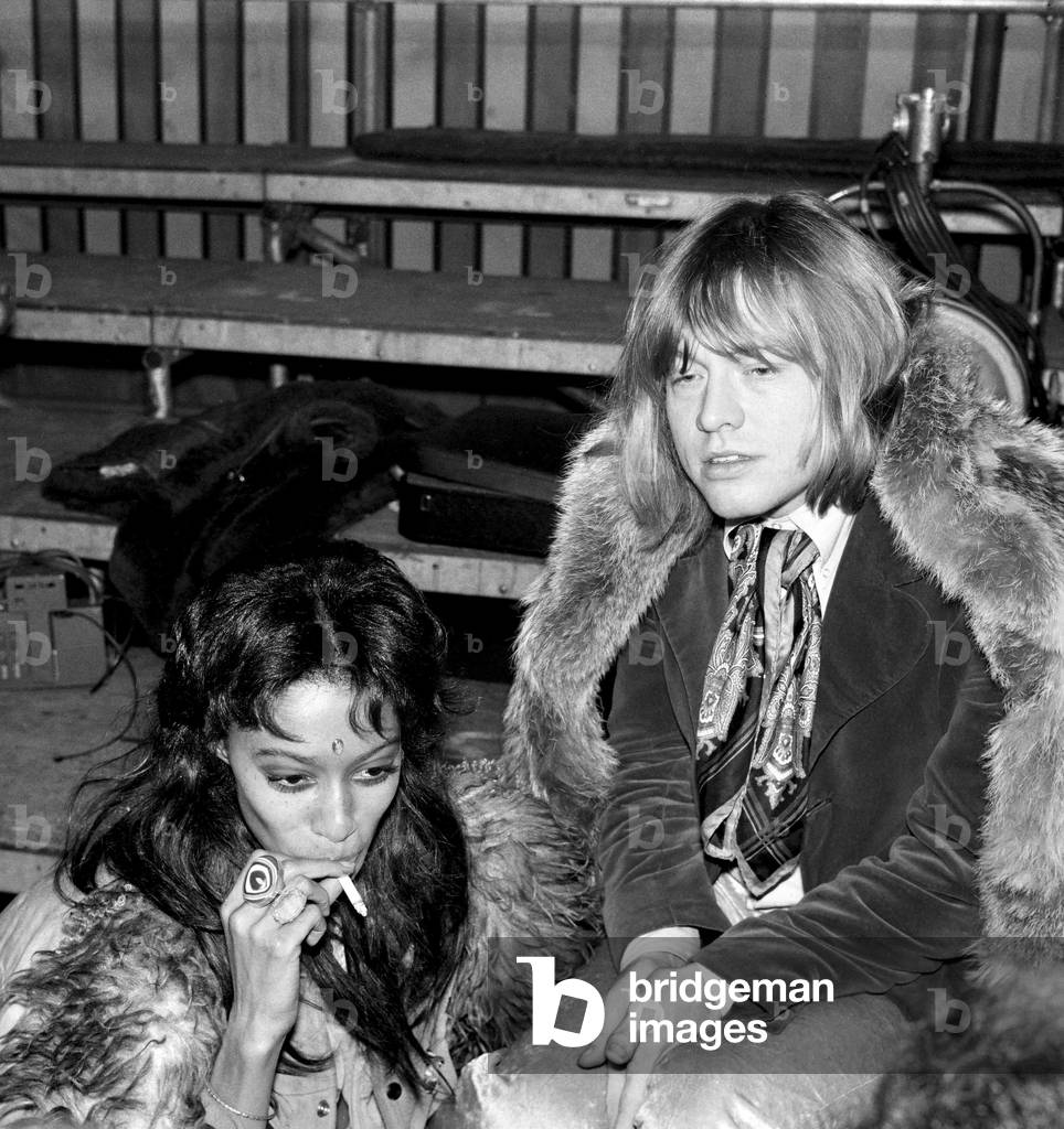 Rolling Stones: Brian Jones at the filming of the Rolling Stones Rock 'n' Roll Circus, which turned out to be his final public appearance with the Stones. He is pictured with model Donyale Luna who played the part of the fire eaters assistant in the Rock 'n' Circus. 11th December 1968 (b/w photo)