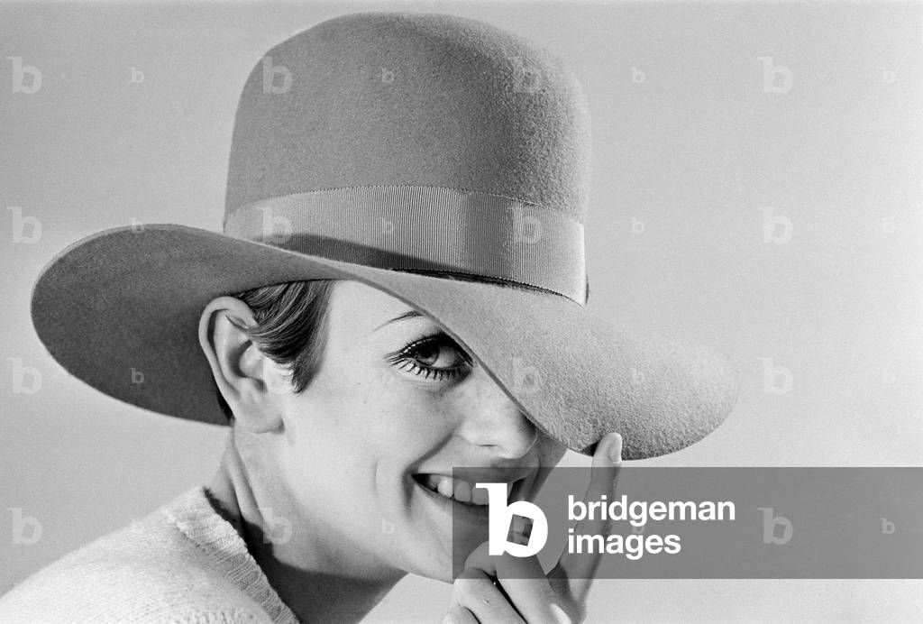 Fashion model Lesley Hornby, better known as Twiggy, modelling hats during a studio photoshoot, December 1966 (b/w photo)