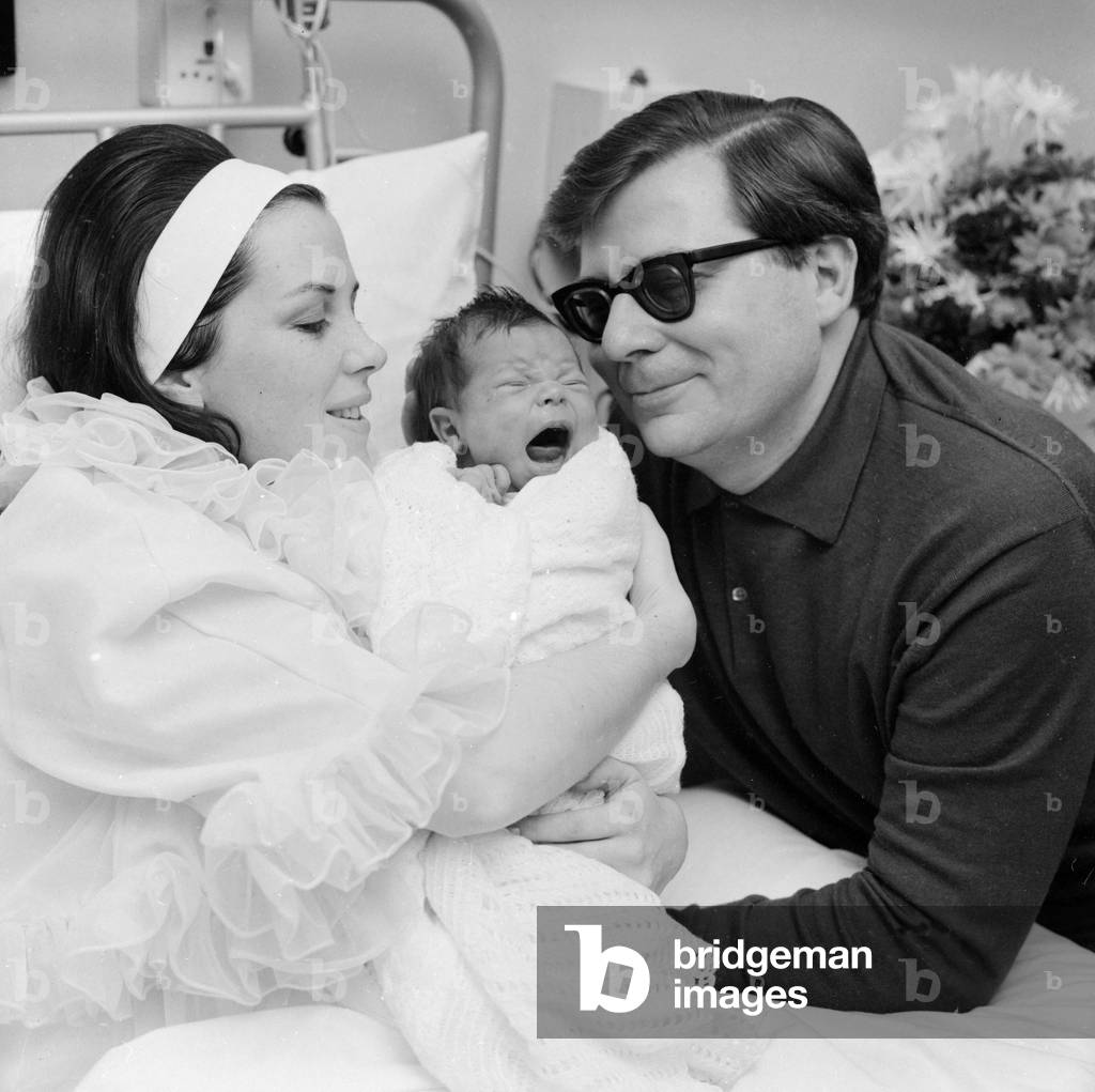 Conductor Sir Edward Thomas Downes and his wife Joan seen here at the Royal Northern Hospital, Holloway Rd, London with their son Caractacus. 15th December 1967 (b/w photo)