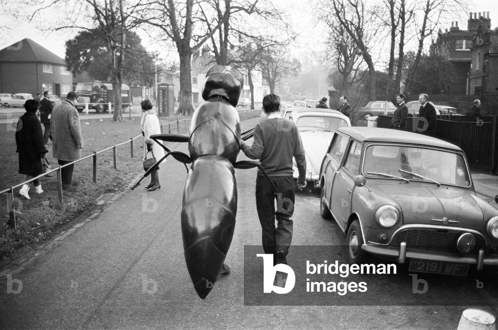 A 'Zarbi', from the Dr Who television serial (written by Bill Struttonwill) ,'The Web Planet'. The Zarbi that left the studio and stood at a bus stop is being led back to the studio by a technician, near to the BBC TV studio at Ealing. The Zarbi (designed by John Wood), has an ant like appearance. Original transmission date 13th February 1965. 5th January 1965 (b/w photo)