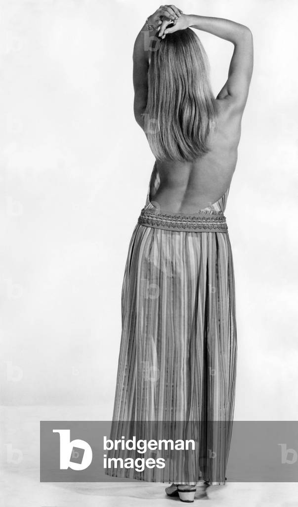 Sexier than the briefest bikini. More provocative than a gallon of French perfume. In a backless dress, a girl can make her mark quite simply by turning her back on the holiday crowd. 
August 1969