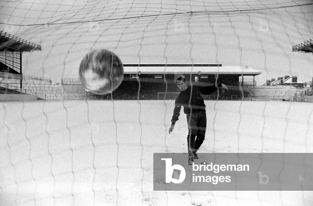 Arsenal's transfer lister forward, Bobby Gould, who was to have played for Arsenal reserves and West Ham reserves at Highbury, donned his track-suit and loosened up on the pitch for our cameraman, in very thick snow in front of a completely deserted stadium. London's only goal in 1st Class Football - scorer Bobby Gould. November 1969 (photo)