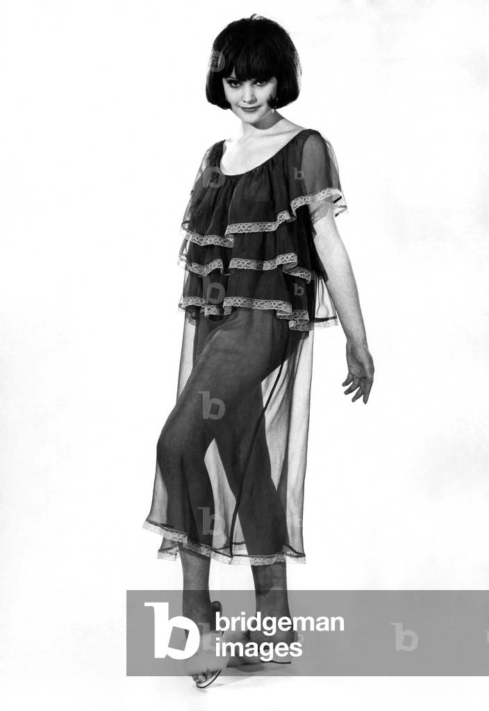 Woman wearing short sleeved see through top with leg warmers, July 1963