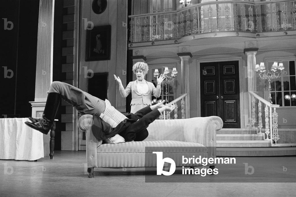 Actor Robert Lindsay in his role as Bill Snibson in the stage musical Me and My Girl at the Adelphi Theatre in London, performs a somersault over the sofa during the performance. February 1985 (b/w photo)