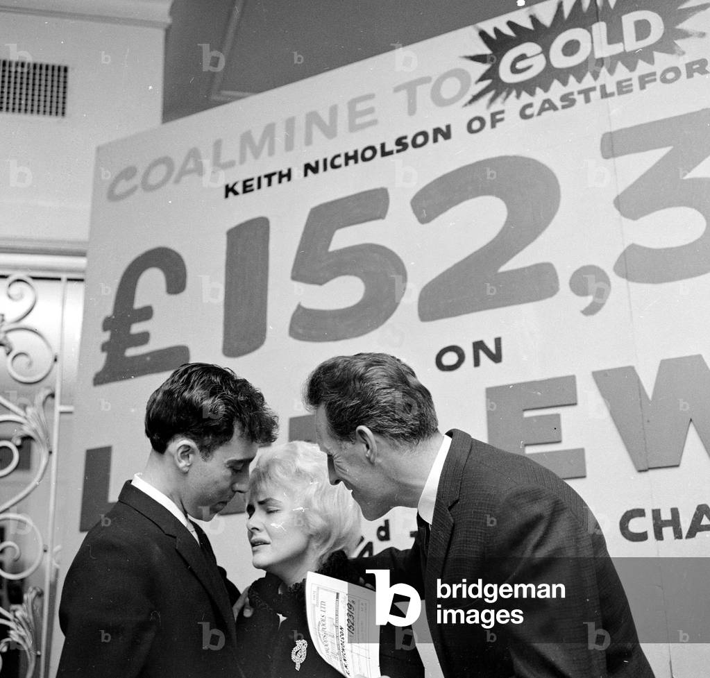 Pools winner Vivienne Nicholson and husband Keith Howard Nicholson receive a cheque for £152,000 from television personality Bruce Forsyth after their recent win, September 1961 (b/w photo)