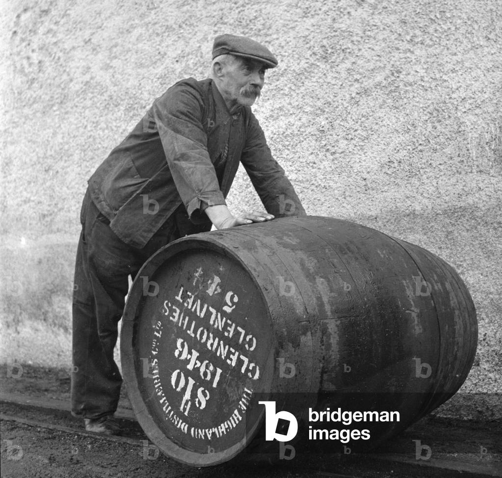 A Glenlivet Distillery worker rolls a barrel of their finest single malt whisky to the bonded warehouse where it willl mature for a minimum of eight years. Circa 1946