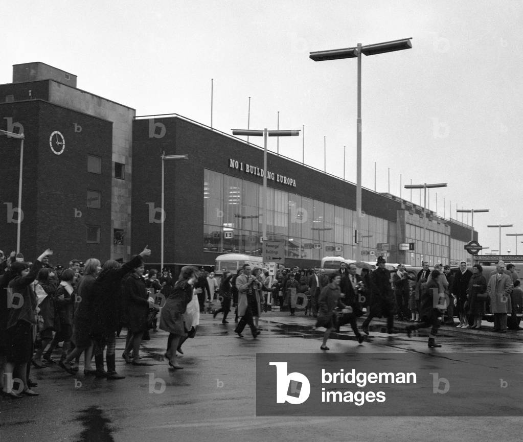 The Beatles arrive at London airport from Sweden. Fans running across the airport to greet them, 31st October 1963 (b/w photo)
