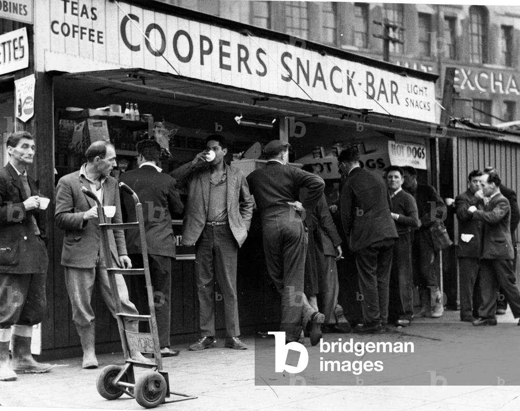 A cup of tea makes a welcome break for these men, many of whom have been working in and around Cardiff's Custom House Street, unloading produce since first light, May 1960 (b/w photo)