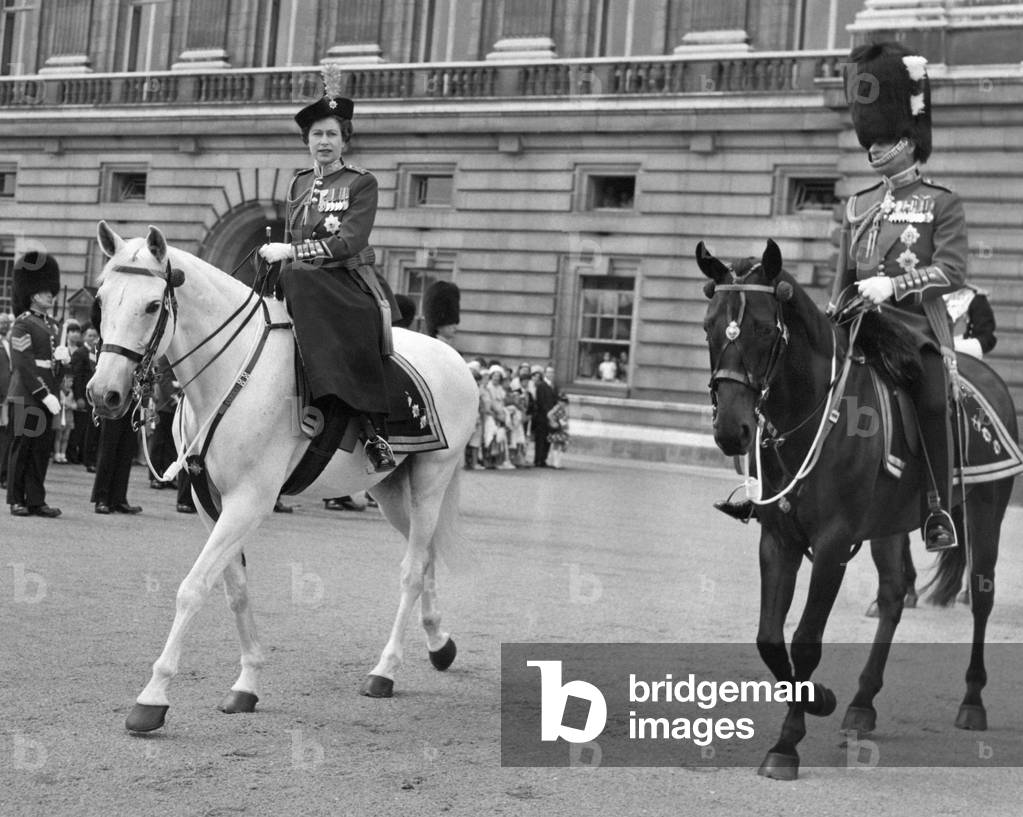 Queen Elizabeth II wearing the Scarlet Tunic of the Irish Guards, leaves Buckingham Palace on police horse, Doctor, with Prince Philip riding, Neill during the trooping of the colour ceremony to mark her official birthday. 11th June 1966 (b/w photo)