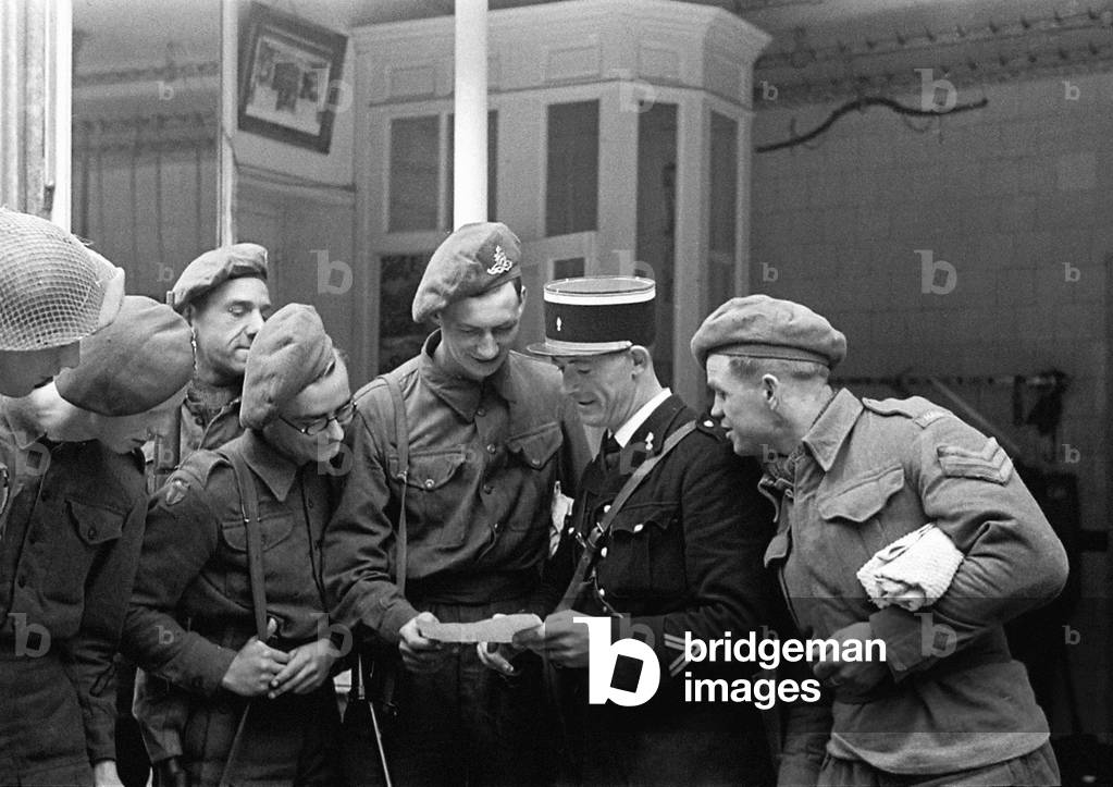 British troops talking to a local gendarme in a Normandy town in Northern France shortly after the D-Day landings begun the Allied invasion of the continent during World War Two July 1944 (b/w photo)
