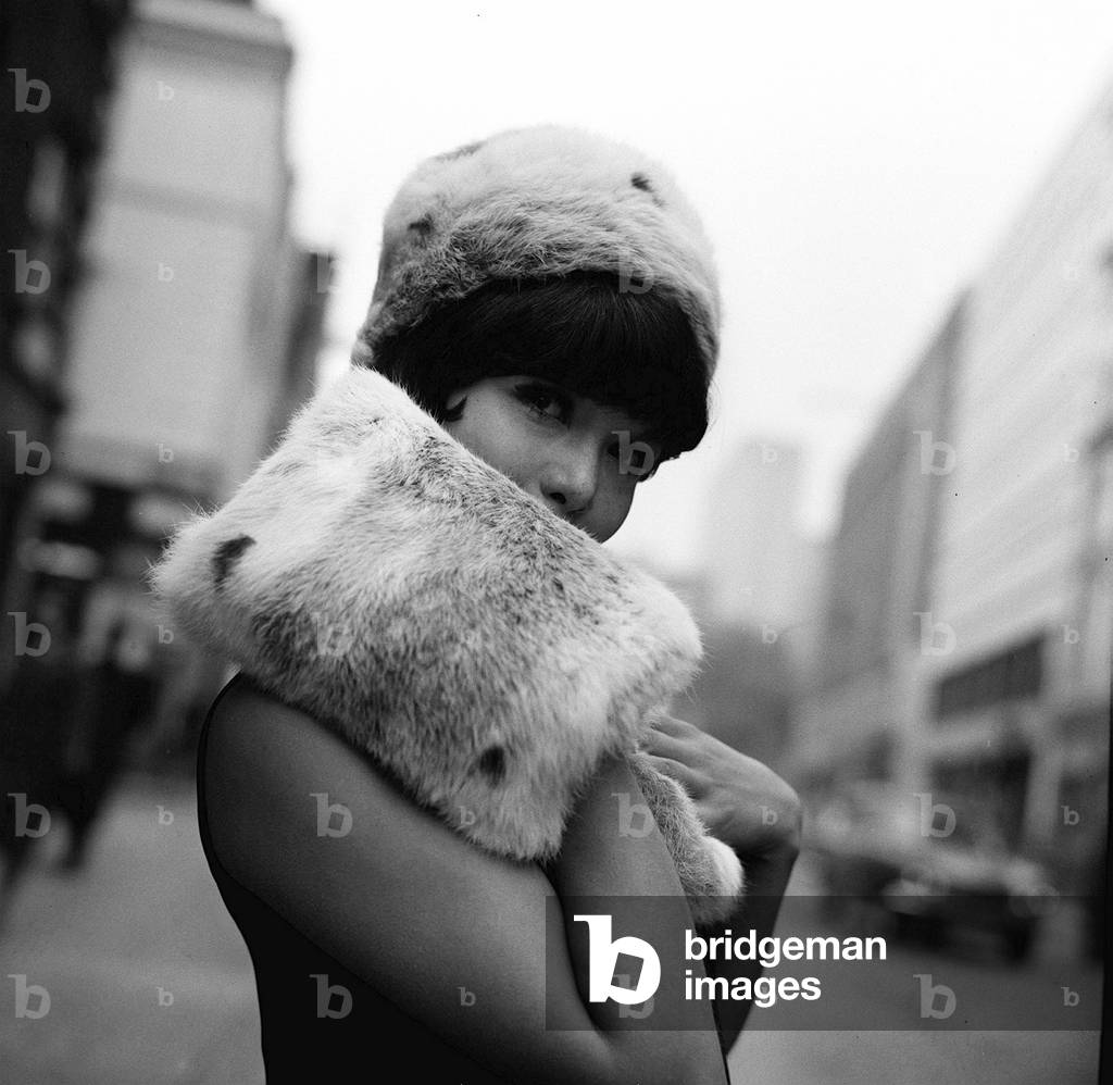 A model wears a fur hat and muff, June 1965 (b/w photo)
