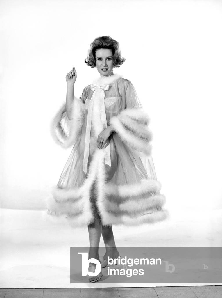 Model Rita Royce wearing marabou fur trimmed nightie, December 1963 (b/w photo)