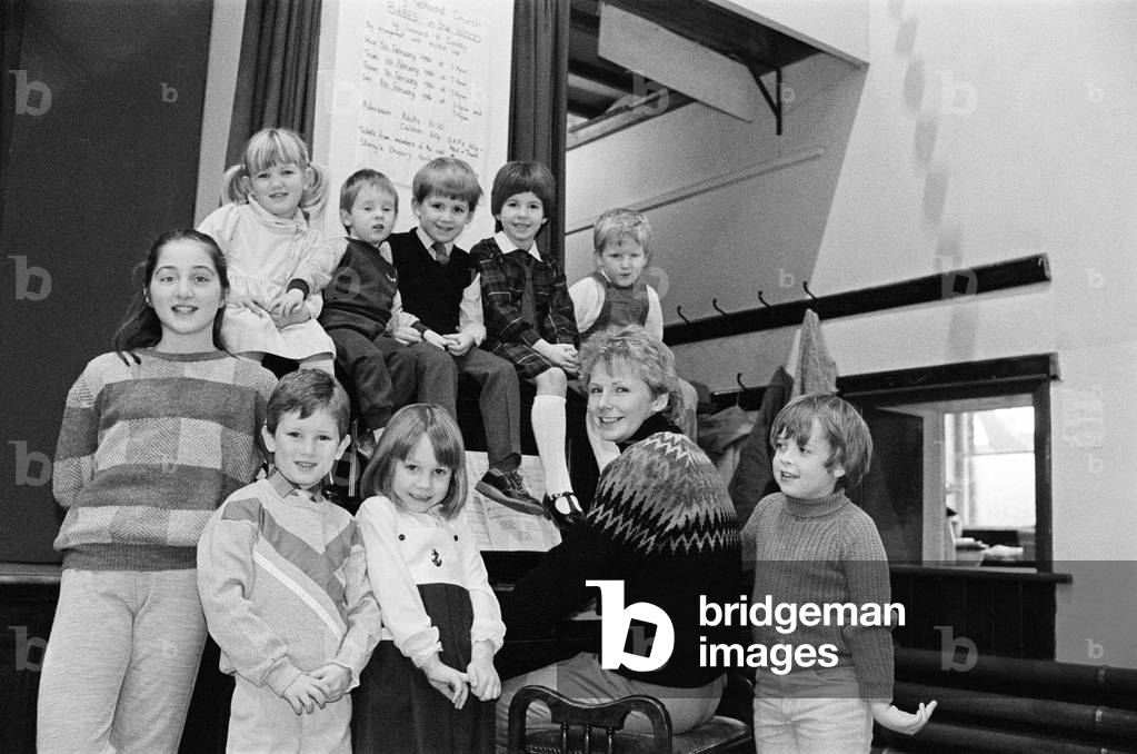 Almondbury Methodist Junior Church Christmas Party, singing carols round the piano. 19th December 1985 (b/w photo)