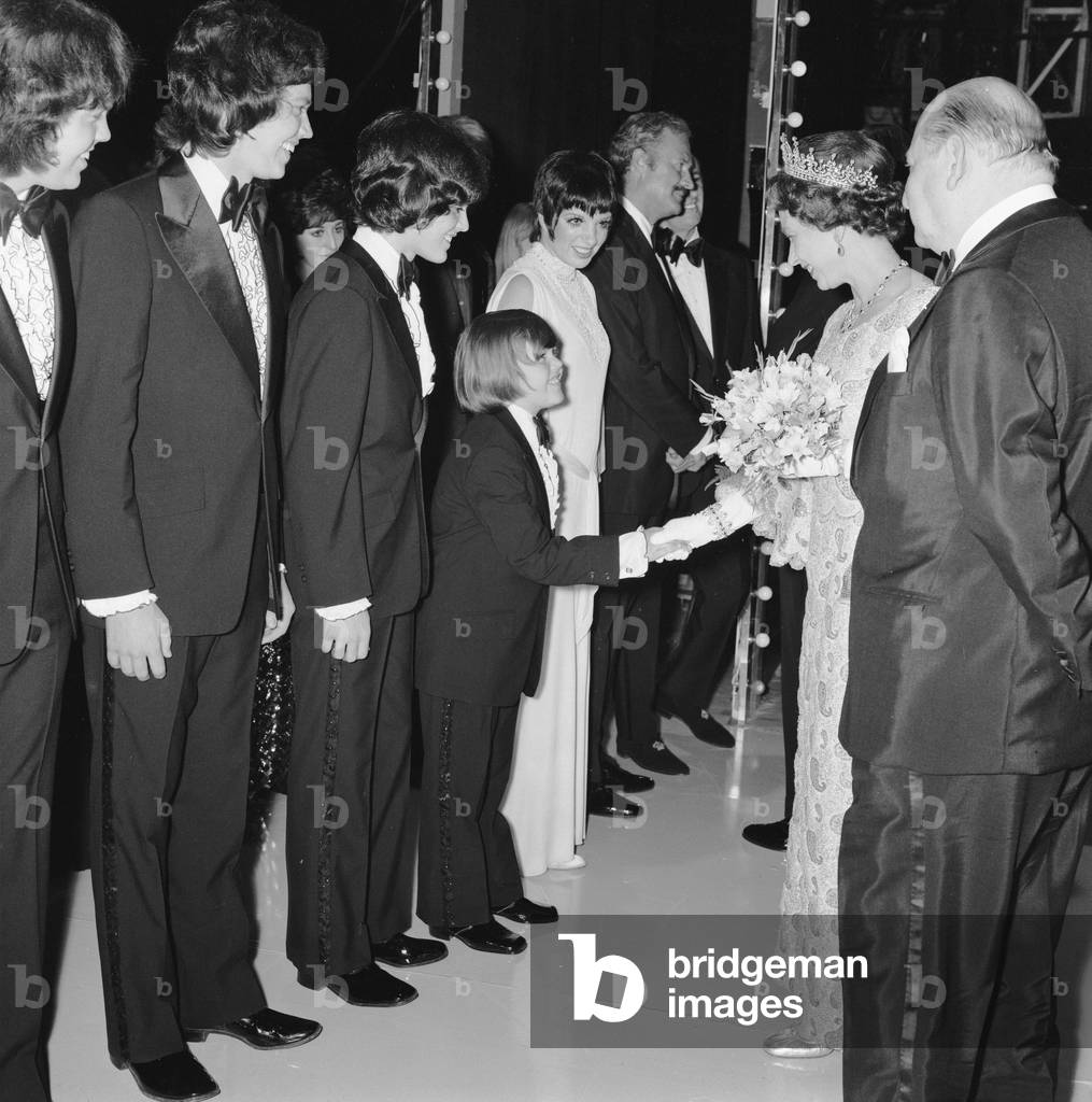 Her Majesty Queen Elizabeth II, escorted by Media mogul Lew Grade (right), shakes hands with a member of the Osmonds, 22nd May 1972 (b/w photo)
