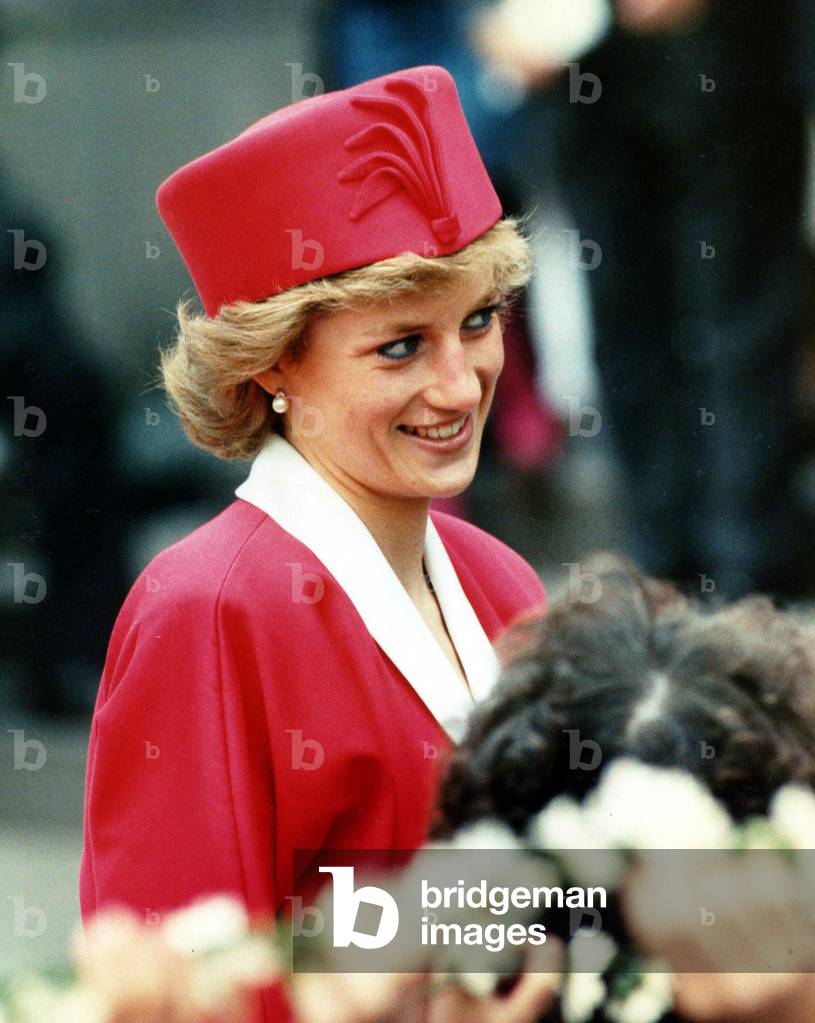 Princess Diana on a walkabout during visit wearing red suit and red pillbox hat looking coy, May 1989 (photo)