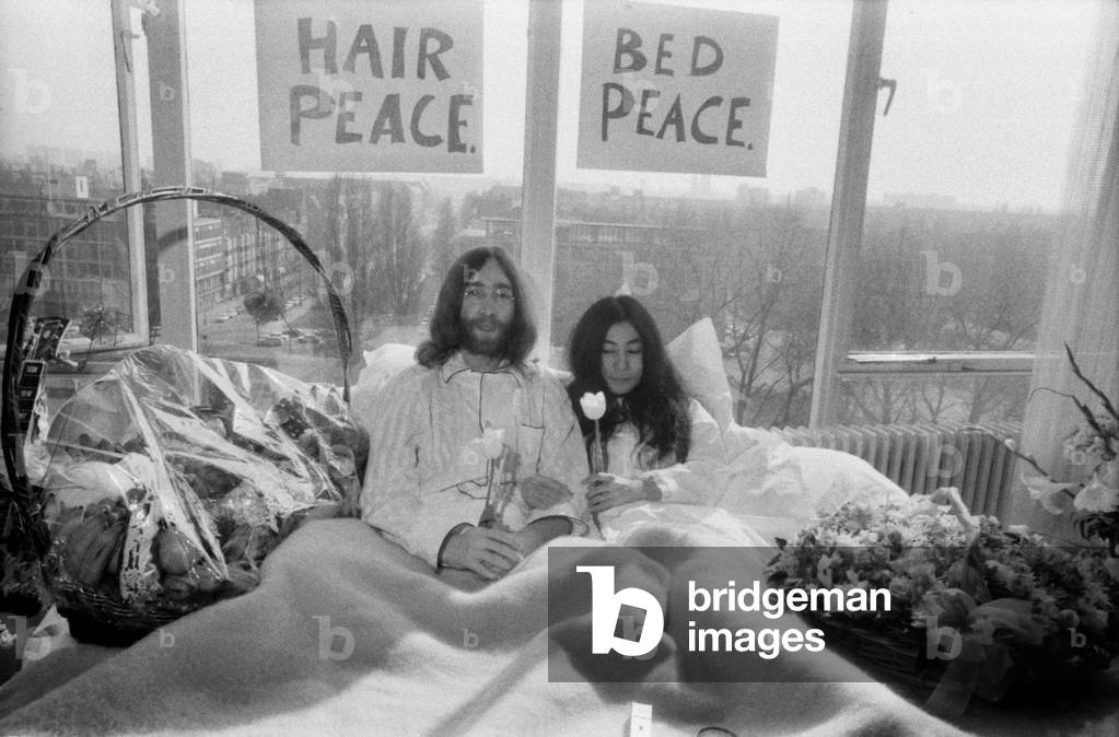 John Lennon and his wife Yoko Ono are having a weeks love-in their room at the Hilton Hotel, Amsterdam. They will stay in bed for seven days - with fruit, flowers and peace signs, March 1969