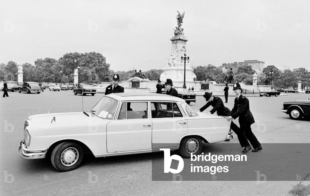 Police remove a Mercedes 200D car from in front of Buckingham Palace. 11th July 1968 (b/w photo)
