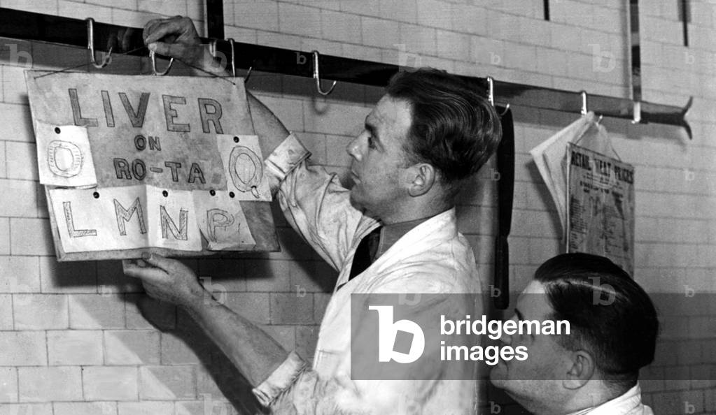 A butcher shows his method of giving everyone a 'turn' for off the ration meats, 28th January 1947 (b/w photo)
