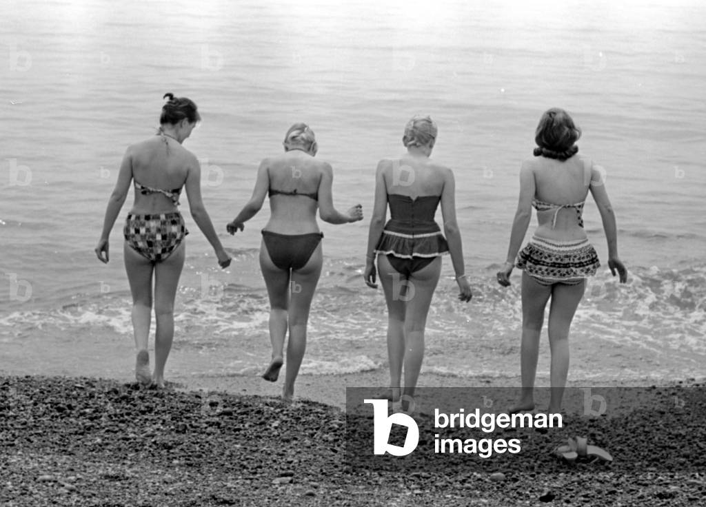 A group of women go for a swim on the beach at Brighton beach July 1958 (b/w photo)