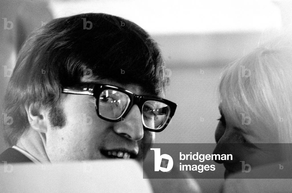 7 February 1964 John Lennon with wife Cynthia on the aircraft to New York, USA for the first Beatles tour of America.