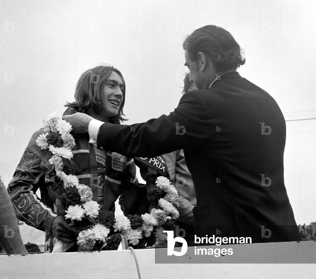 John Player British Grand Paix, Silverstone. Ron Haslam being presented with the winner's cup by Mr. Nicholls of the Daily Express, August 1977 (b/w photo)