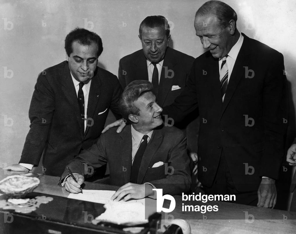 Dennis Law signs for Manchester United from Torino for £115,000 watched on by team manager (right) Matt Busby. 12th July 1962 (photo)