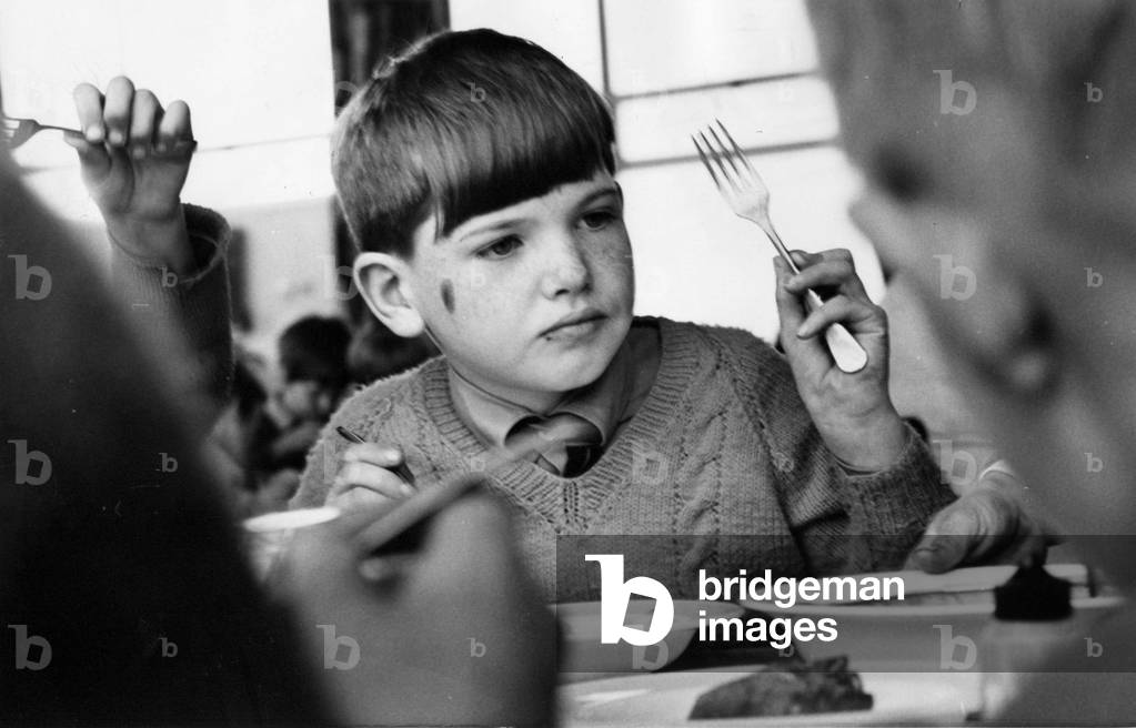 A young pupils enjoying his school lunch, c.1970 (b/w photo)