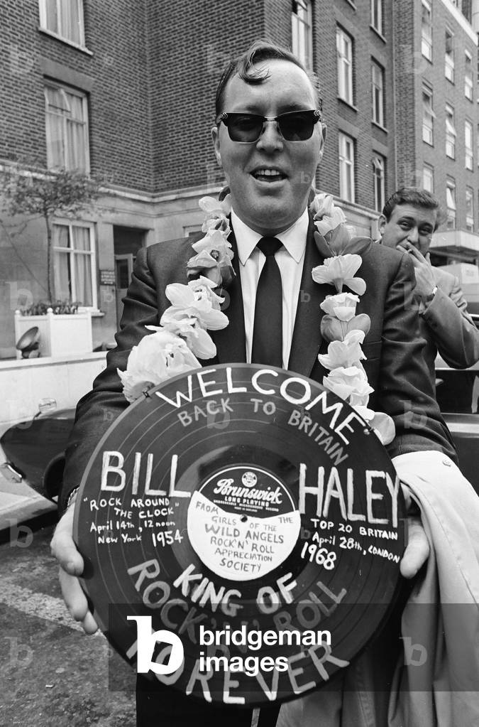 American rock and roll singer Bill Haley holds a record with a Welcome Back to Britain message, shortly before his appearance at the Royal Albert Hall, London with his band The Comets. 28th April 1968 (b/w photo)
