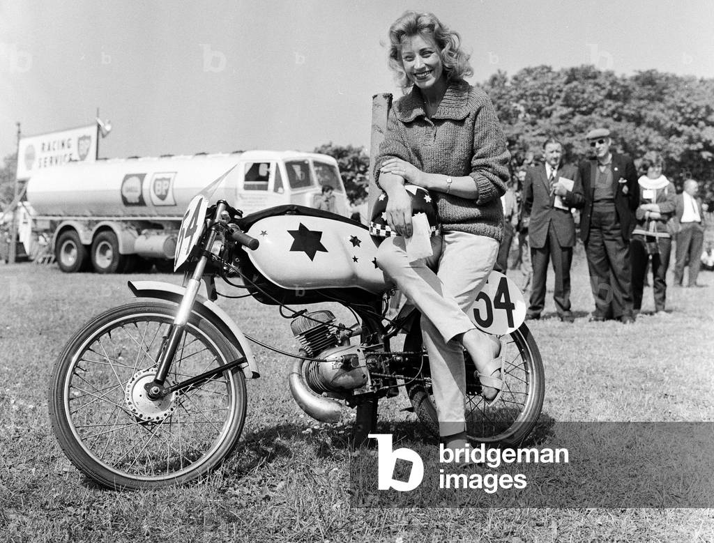 Beryl Swain waiting to weigh in for the 50cc race. 7th June 1962 (b/w photo)