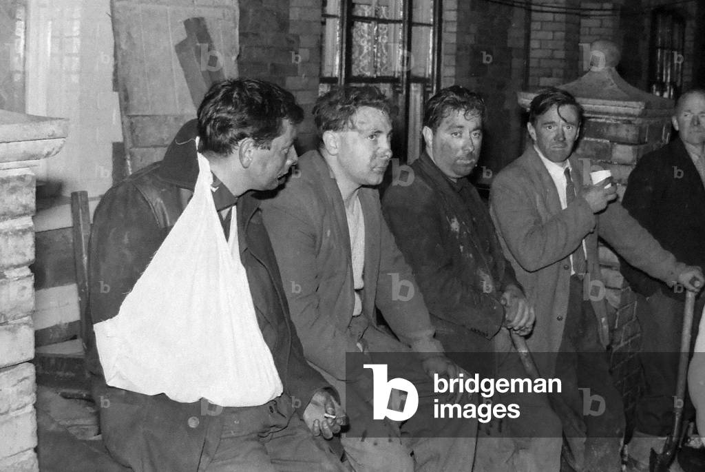 Rescue workers take a break during the search for victims engulfed when a slag heap collapsed at Aberfan, South Wales, 21st October 1966 (b/w photo)