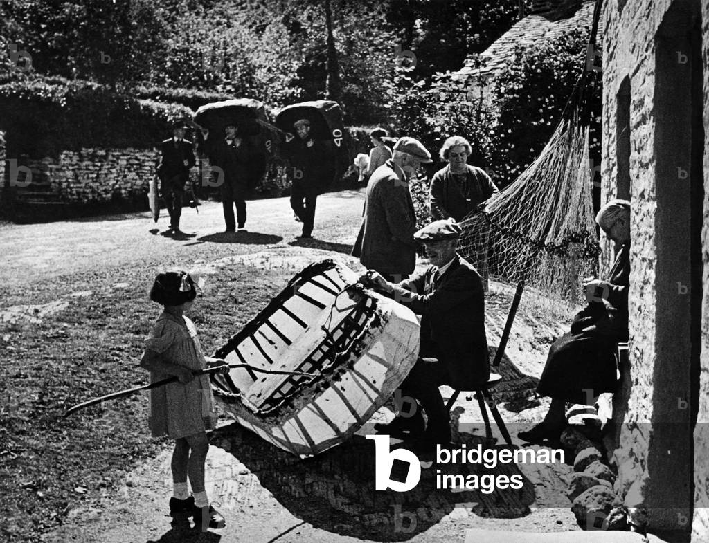 A Village street scene. Fishermen, Net menders, knitters and coracle builders are all at work, and yet, pervading it all is a feeling of leisure and peace, that can only be found amongst craftsmen and in ancient and quiet places, c. 1945 (b/w photo)