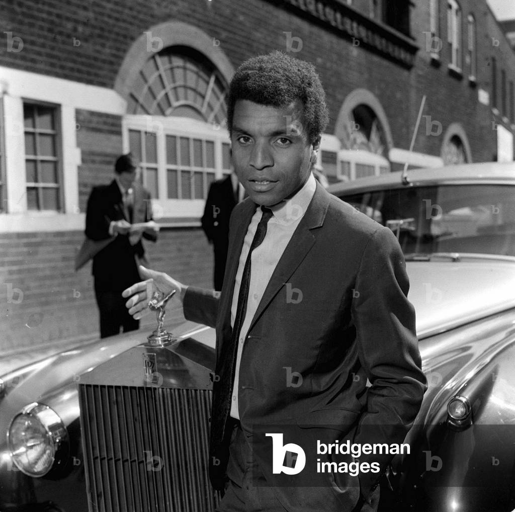 English pop singer Kenny Lynch outside Bow Street Magistrate Court awaiting a hearing on a driving charge, 1965 (b/w photo)