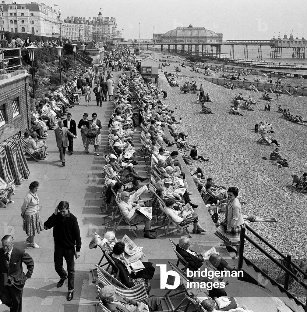 Whitsunday holiday scenes, with the pier in the background, in Eastbourne, Sussex. 10th June 1962 (b/w photo)